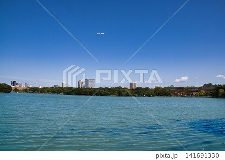 福岡市の観光名所・大濠公園と福岡空港に向けて上空を飛ぶ旅客機 141691330