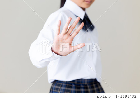 拒否のポーズをする制服姿の中学生の女の子・グレーバック 拒否のポーズをする制服姿の中学生の女の子・グレーバック 141691432