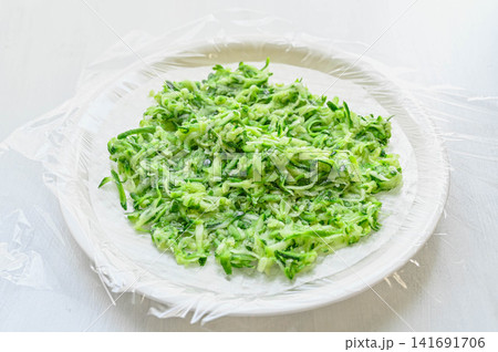 ライスペーパーの上にのせた塩もみズッキーニの細切り ライスペーパーの上にのせた塩もみズッキーニの細切り 141691706