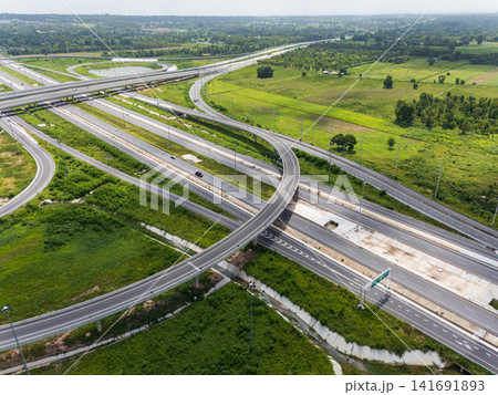 Drone shot a large highway interchange crossing over green farmlands in Thailand Drone shot a large highway interchange crossing over green farmlands in Thailand 141691893