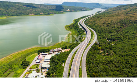 Drone shot The M6 motorway Nakhon Ratchasima Province - Bang Pa-in Lam Ta Khong River and Mountain. Motorway Korat Thailand Drone shot The M6 motorway Nakhon Ratchasima Province - Bang Pa-in Lam Ta Khong River and Mountain. Motorway Korat Thailand 141691966