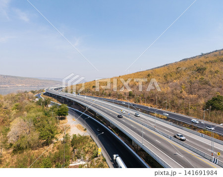 Drone shot aerial view landscape of the M6 motorway Expressway Nakhon Ratchasima Province - Bang Pa-in. Lam Ta Khong River and Mountain. Drone shot of scenic landscape rural place traffic. Nakhon Drone shot aerial view landscape of the M6 motorway Expressway Nakhon Ratchasima Province - Bang Pa-in. Lam Ta Khong River and Mountain. Drone shot of scenic landscape rural place traffic. Nakhon 141691984