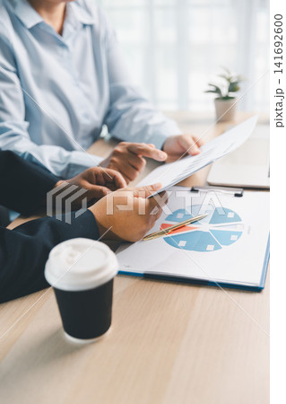 Business consultant explaining financial report during office meeting, with hands gesturing over charts, showing strategy, planning and professional advice. Business consultant explaining financial report during office meeting, with hands gesturing over charts, showing strategy, planning and professional advice. 141692600