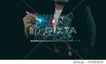 Businessman using stylus pen with glowing digital city map and pin pointers on laptop screen, concept of navigation and logistics tracking. Businessman using stylus pen with glowing digital city map and pin pointers on laptop screen, concept of navigation and logistics tracking. 141693624