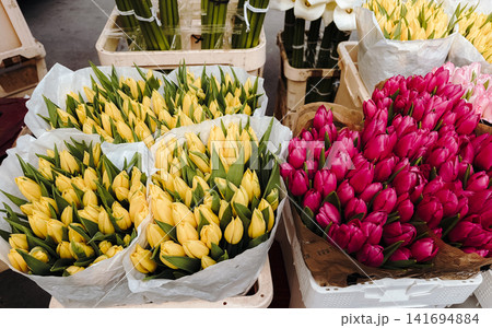 Yellow and pink tulip bouquets displayed at flower market. Bright spring floral concept for seasonal shopping, celebration, gifting and fresh decoration 141694884