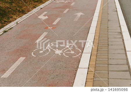 Bicycle symbol and directional arrows painted on urban bike lane. Concept of sustainable transport, mobility and healthy lifestyle. Bicycle symbol and directional arrows painted on urban bike lane. Concept of sustainable transport, mobility and healthy lifestyle. 141695098