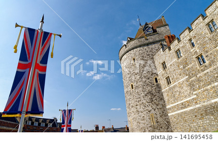 The Curfew Tower and historic stone ramparts at Windsor Castle decorated with Union Jack banners The Curfew Tower and historic stone ramparts at Windsor Castle decorated with Union Jack banners 141695458