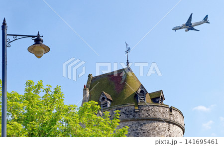 The medieval Curfew Tower at Windsor Castle under a bright blue sky with a passing airplane The medieval Curfew Tower at Windsor Castle under a bright blue sky with a passing airplane 141695461