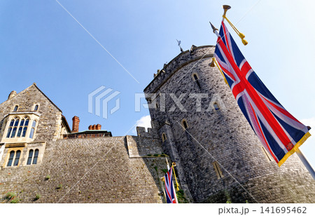 The Curfew Tower and historic stone ramparts at Windsor Castle decorated with Union Jack banners 141695462