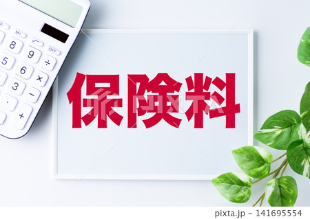 保険料の文字のホワイトボードと白い電卓 保険料の文字のホワイトボードと白い電卓 141695554