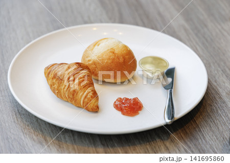 香ばしいクロワッサンと丸パンにジャムとバターを添えたプレート 香ばしいクロワッサンと丸パンにジャムとバターを添えたプレート 141695860