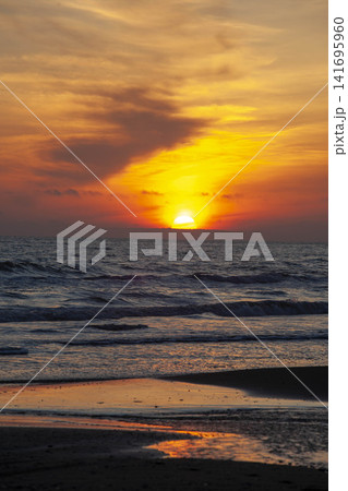 北海道から見える利尻島の夕焼け、波打つ海岸の黄金色に染まる景観 141695960