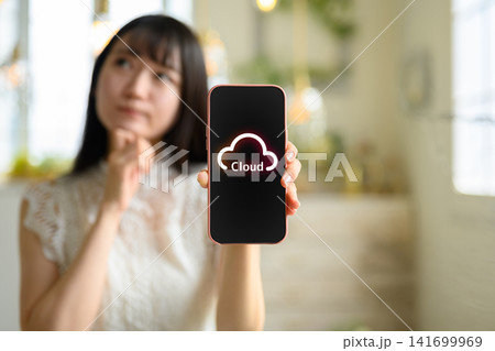 スマートフォンでクラウドサービスを操作する女性 スマートフォンでクラウドサービスを操作する女性 141699969