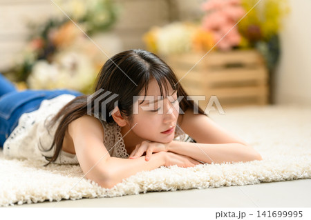 ラグの上でくつろぐ若い女性 ラグの上でくつろぐ若い女性 141699995