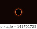 A dramatic total solar eclipse captured against a dark background, featuring the Moon completely covering the Sun and creating a brilliant glowing corona. 141701723