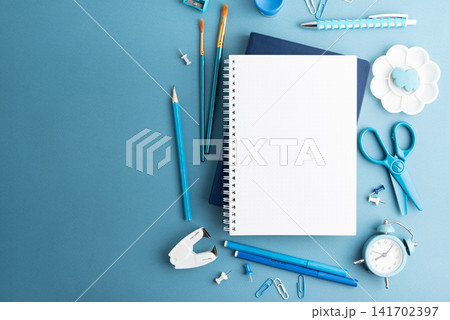 Creative workspace arrangement with art supplies and stationery on blue background 141702397