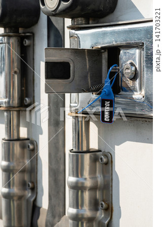 Vertical close up of a plastic security seal on a truck latch Vertical close up of a plastic security seal on a truck latch 141703221