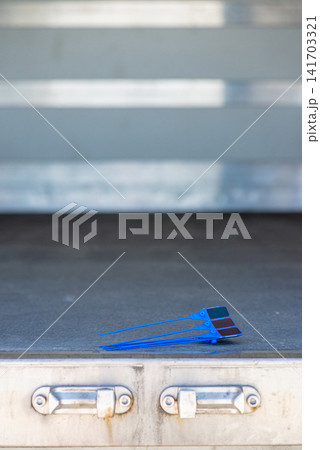 Blue plastic security tag lying on a metal step of a truck Blue plastic security tag lying on a metal step of a truck 141703321