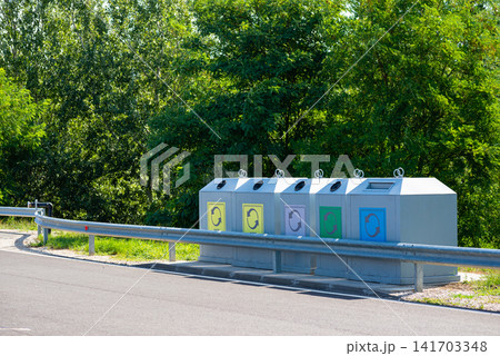 Garbage recycling bins station located next to a countryside road Garbage recycling bins station located next to a countryside road 141703348