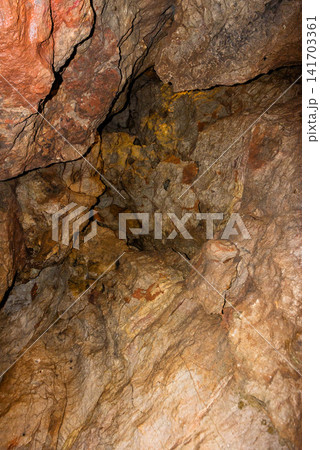 Close-up texture of a rough natural limestone wall inside a dark cave 141703361