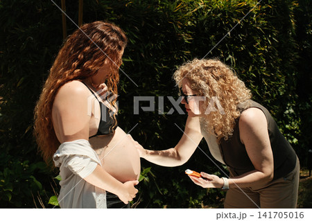 Pregnant woman enjoying a peaceful outdoor maternity lifestyle portrait 141705016