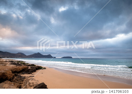 Coastal landscape with wet sand and stones at the beach of Porto Santo island Coastal landscape with wet sand and stones at the beach of Porto Santo island 141706103