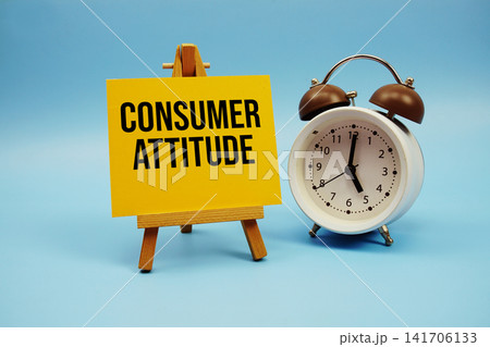 Consumer Attitude text written on paper card and alarm clock on blue background 141706133