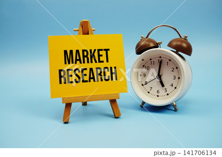 Market Research text written on paper card and alarm clock on blue background 141706134