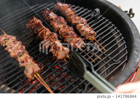 grilled meat skewers cooking on ceramic kamado barbecue grill grilled meat skewers cooking on ceramic kamado barbecue grill 141706864