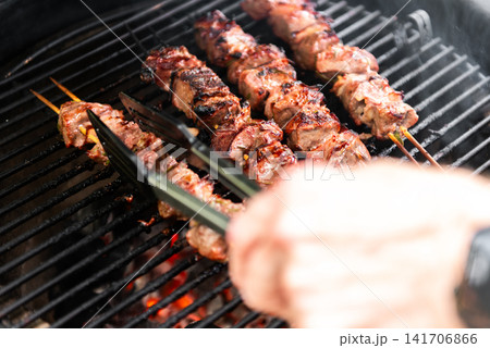 grilled meat skewers cooking on ceramic kamado barbecue grill grilled meat skewers cooking on ceramic kamado barbecue grill 141706866