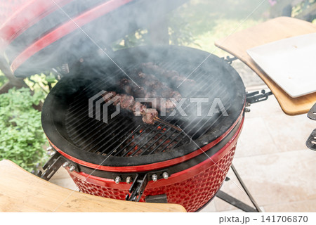 grilled meat skewers cooking on ceramic kamado barbecue grill grilled meat skewers cooking on ceramic kamado barbecue grill 141706870