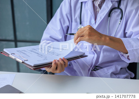 Cardiologist doctor working in clinic hospital writing notes records on clipboard. Cardiologist doctor working in clinic hospital writing notes records on clipboard. 141707778