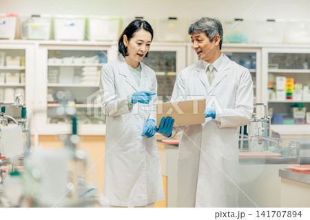 実験室で顕微鏡を使用して研究を行う研究者 141707894