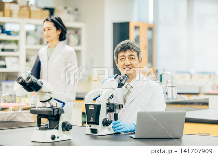 実験室で顕微鏡を使用して研究を行う研究者 実験室で顕微鏡を使用して研究を行う研究者 141707909