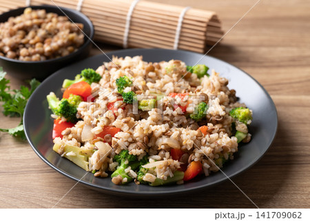 Lentil fried rice with broccoli and bell peppers on black plate, Healthy Asian style vegetarian food Lentil fried rice with broccoli and bell peppers on black plate, Healthy Asian style vegetarian food 141709062