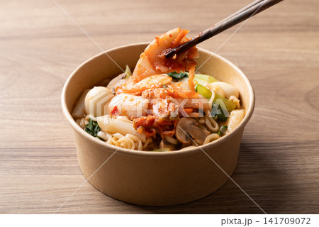Eating instant noodle soup with kimchi, bok choy, champignon mushroom, quail egg and Tteokbokki  141709072