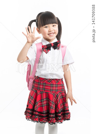 Cute Asian schoolgirl waving hand and smiling, back to school greeting on white background. Cute Asian schoolgirl waving hand and smiling, back to school greeting on white background. 141709388