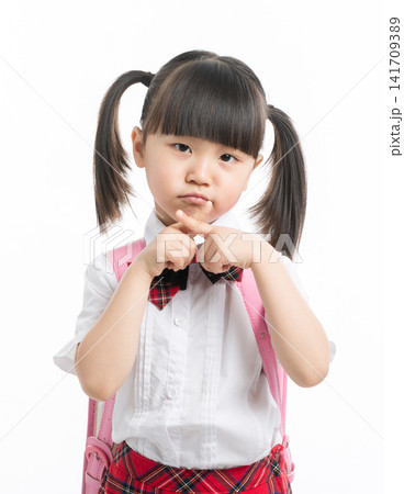 Asian little girl in school uniform making cross sign with hands, showing refusal or stop. Asian little girl in school uniform making cross sign with hands, showing refusal or stop. 141709389