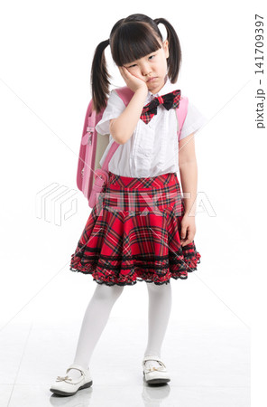 Unhappy and tired Asian schoolgirl with backpack standing against white background, school stress. Unhappy and tired Asian schoolgirl with backpack standing against white background, school stress. 141709397