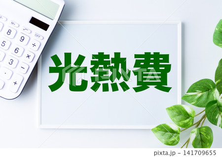 光熱費の文字のホワイトボードと白い電卓 光熱費の文字のホワイトボードと白い電卓 141709655