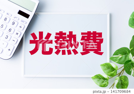 光熱費の文字のホワイトボードと白い電卓 光熱費の文字のホワイトボードと白い電卓 141709684