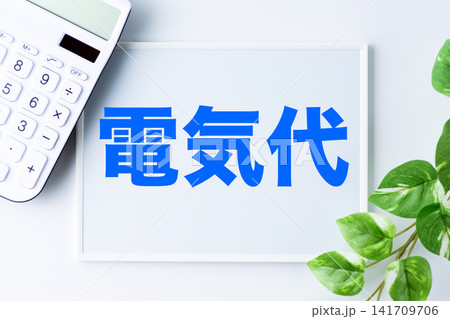 電気代の文字のホワイトボードと白い電卓 電気代の文字のホワイトボードと白い電卓 141709706
