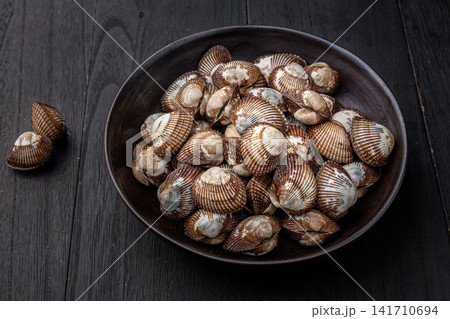 fresh raw blood clams with ridged shells in close up fresh raw blood clams with ridged shells in close up 141710694