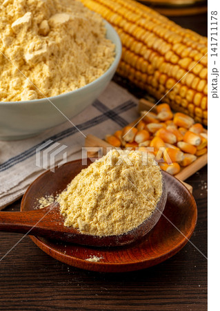 fine yellow corn flour heap with dried corn cob in background fine yellow corn flour heap with dried corn cob in background 141711178