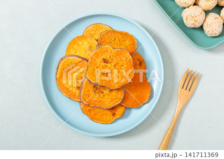 baked sweet potato slices on a plate baked sweet potato slices on a plate 141711369