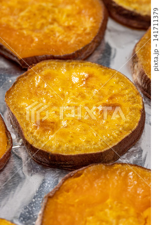 sliced roasted sweet potatoes arranged on plate sliced roasted sweet potatoes arranged on plate 141711379