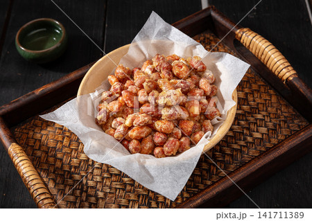 sugar coated peanuts served on a round plate with chopsticks sugar coated peanuts served on a round plate with chopsticks 141711389