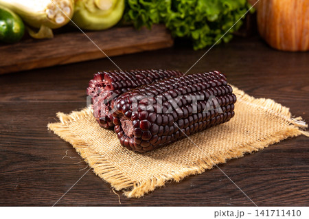 raw black waxy corn cobs isolated on white background raw black waxy corn cobs isolated on white background 141711410