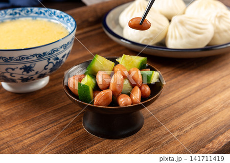 peanut and cucumber salad served in a small plate with chopsticks peanut and cucumber salad served in a small plate with chopsticks 141711419