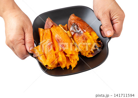 baked moist sweet potato broken open in basket baked moist sweet potato broken open in basket 141711594